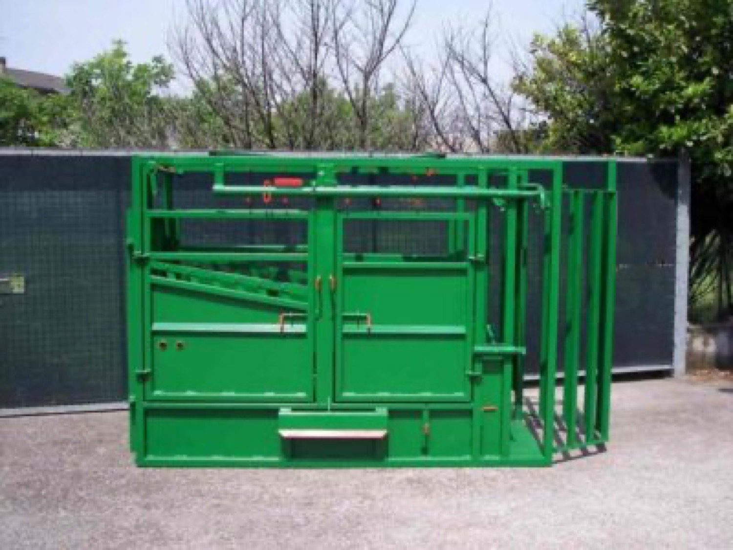 Gabbia di contenzione e trattamento per bovini con porta a chiusura centrale e cancello di bloccaggio a doppio battente.